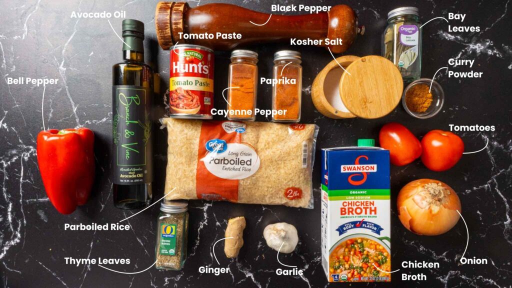 Various ingredients for jollof rice are arranged on a dark surface, each labeled: avocado oil, black pepper, kosher salt, bay leaves, curry powder, tomatoes, chicken broth, onion, garlic, ginger, thyme leaves, parboiled rice, bell pepper, tomato paste.