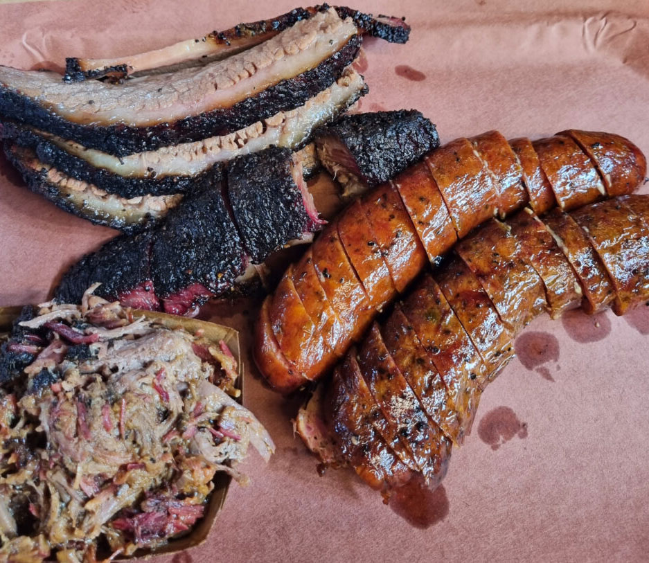 Photo of smoked brisket, pulled pork, and cheese and jalapeno sausage links