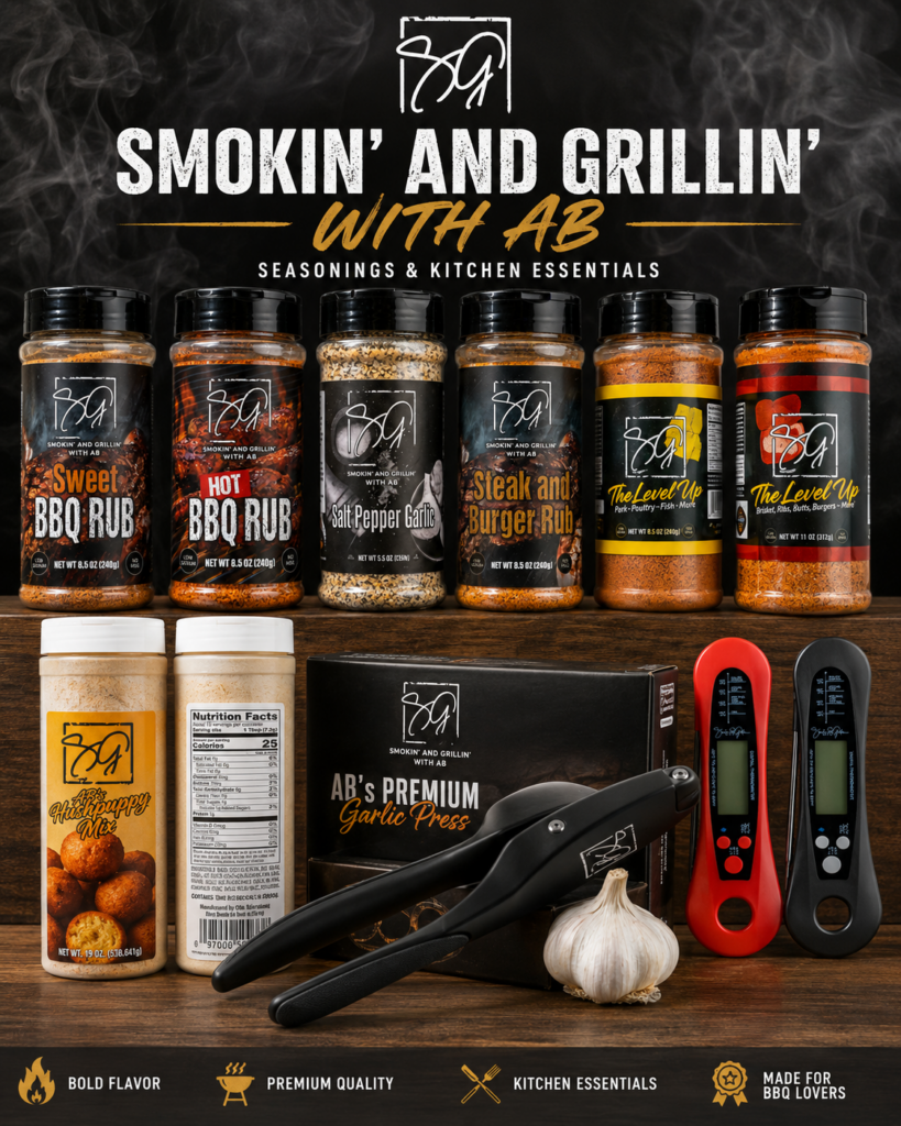 A variety of BBQ rubs, seasonings, and kitchen tools are displayed on a table with garlic. The text reads Smokin and Grillin with AB, featuring bold flavor, premium quality, BBQ essentials, and a recipe index for easy meal inspiration.