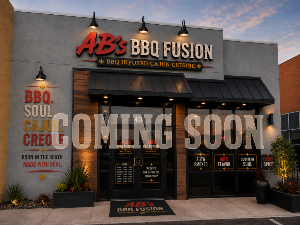 Restaurant storefront with the sign AB&rsquo;s BBQ Fusion and COMING SOON across the glass doors. The building features outdoor lights, plants by the entrance, and BBQ-themed phrases on the exterior wall, all showcasing the spirit of AB&rsquo;s BBQ Fusion.