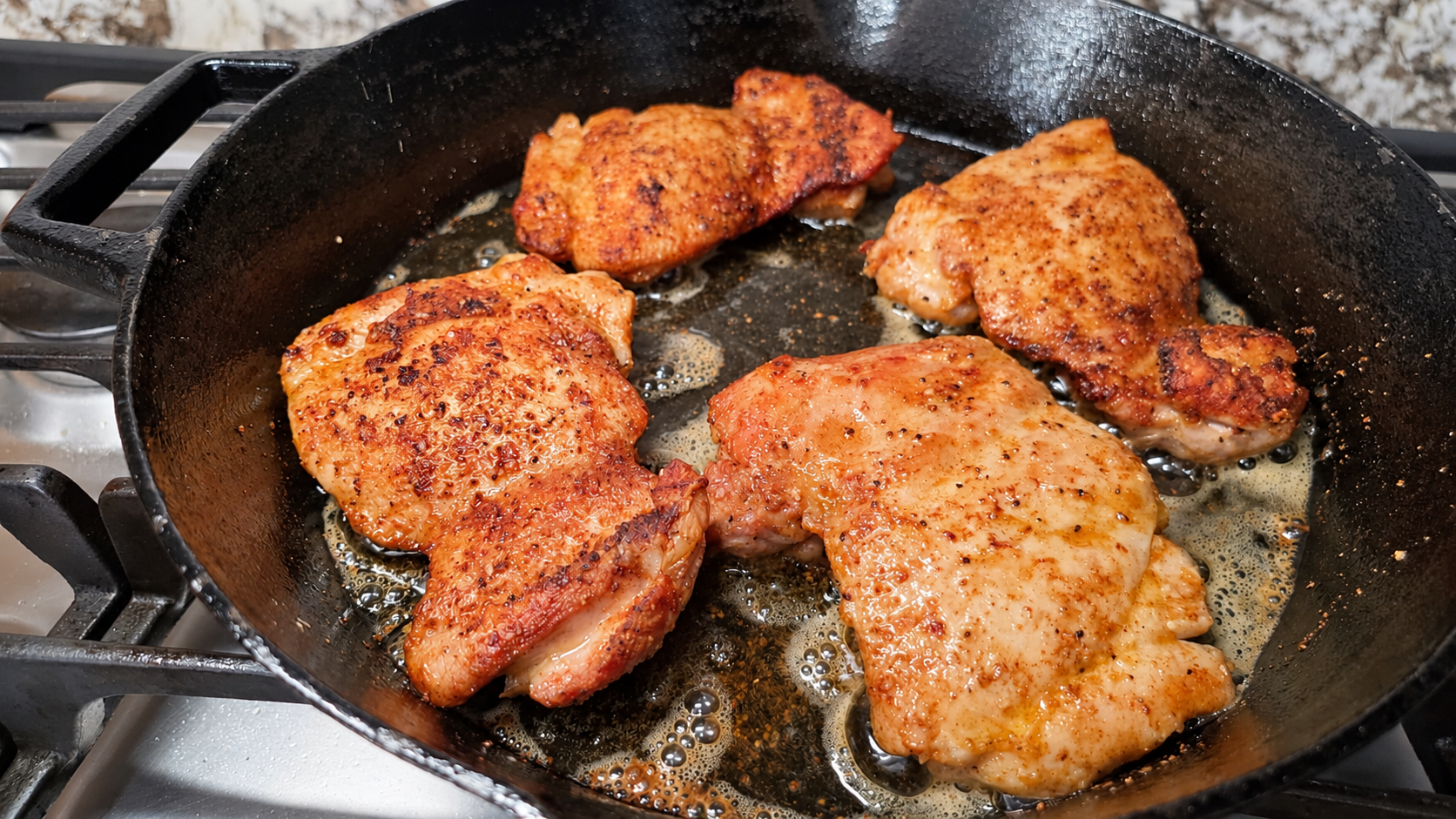 Chicken thighs with a golden-brown sear in a cast-iron skillet before making the peppercorn sauce.
