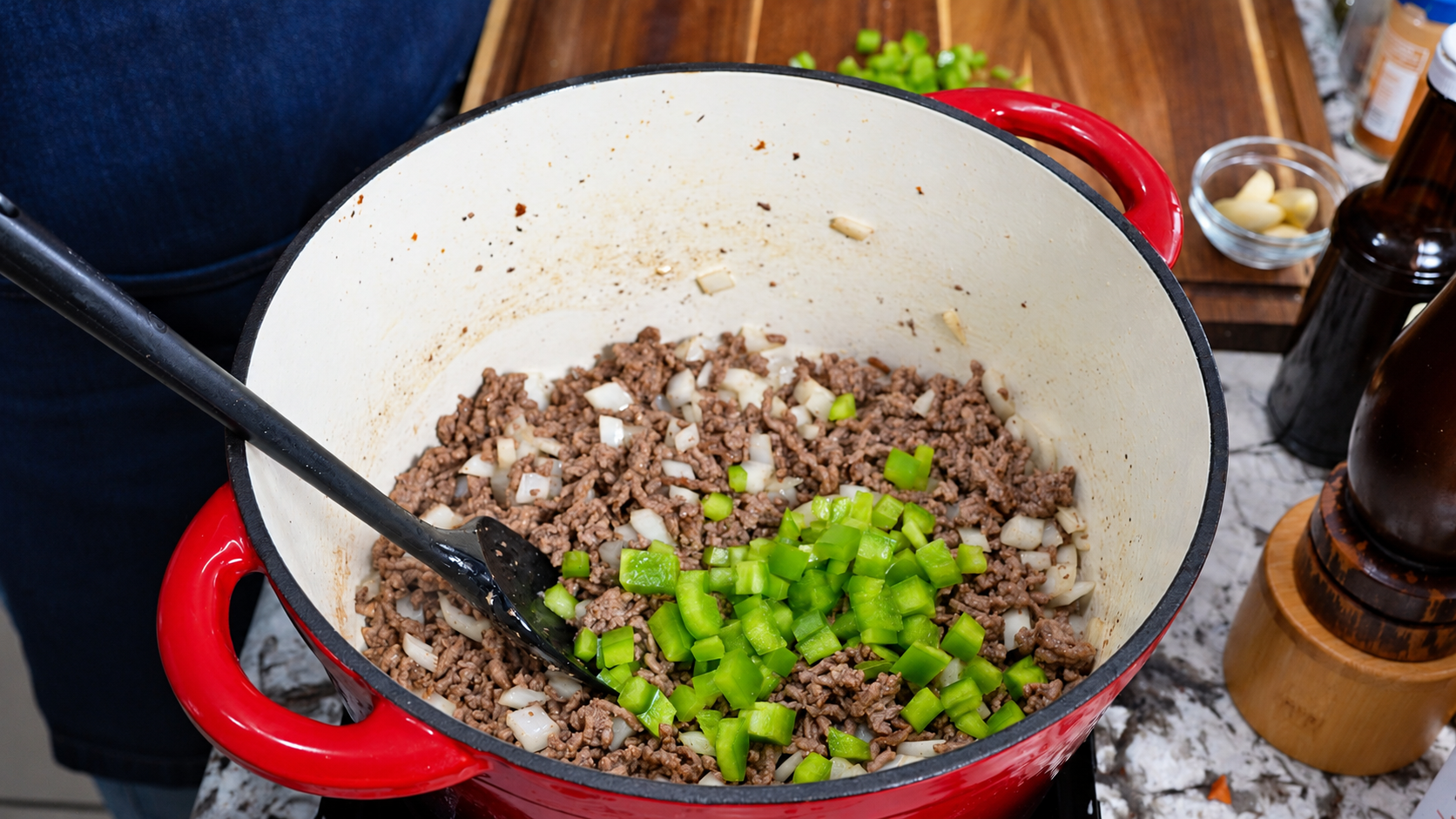 Diced onion and green bell pepper added to browned ground beef.