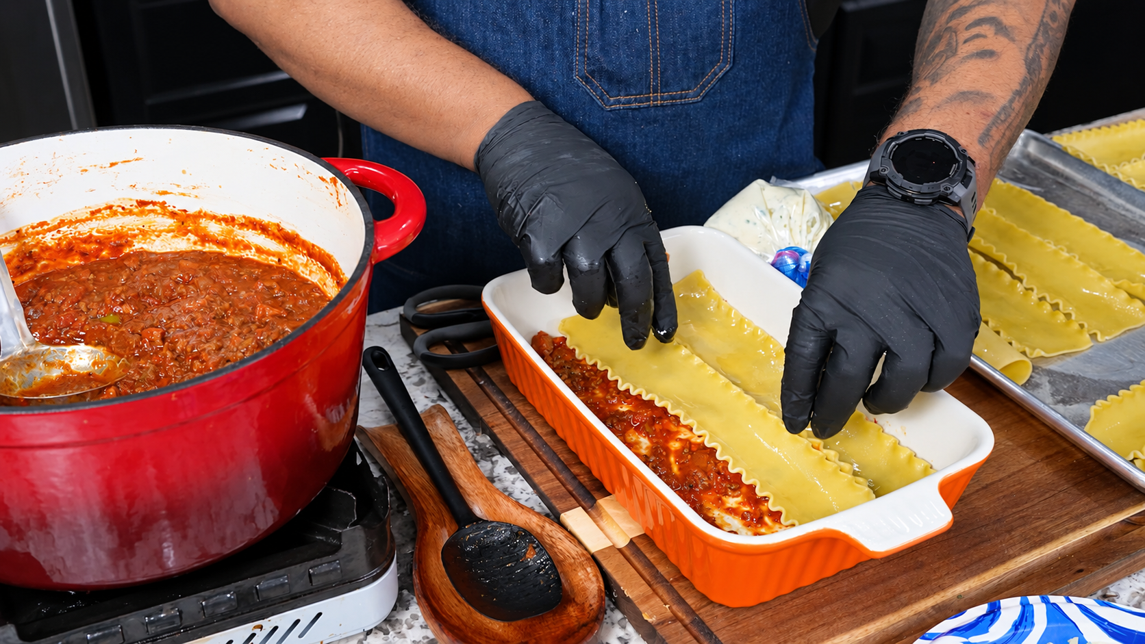 Lasagna noodles arranged over meat sauce in the baking dish.